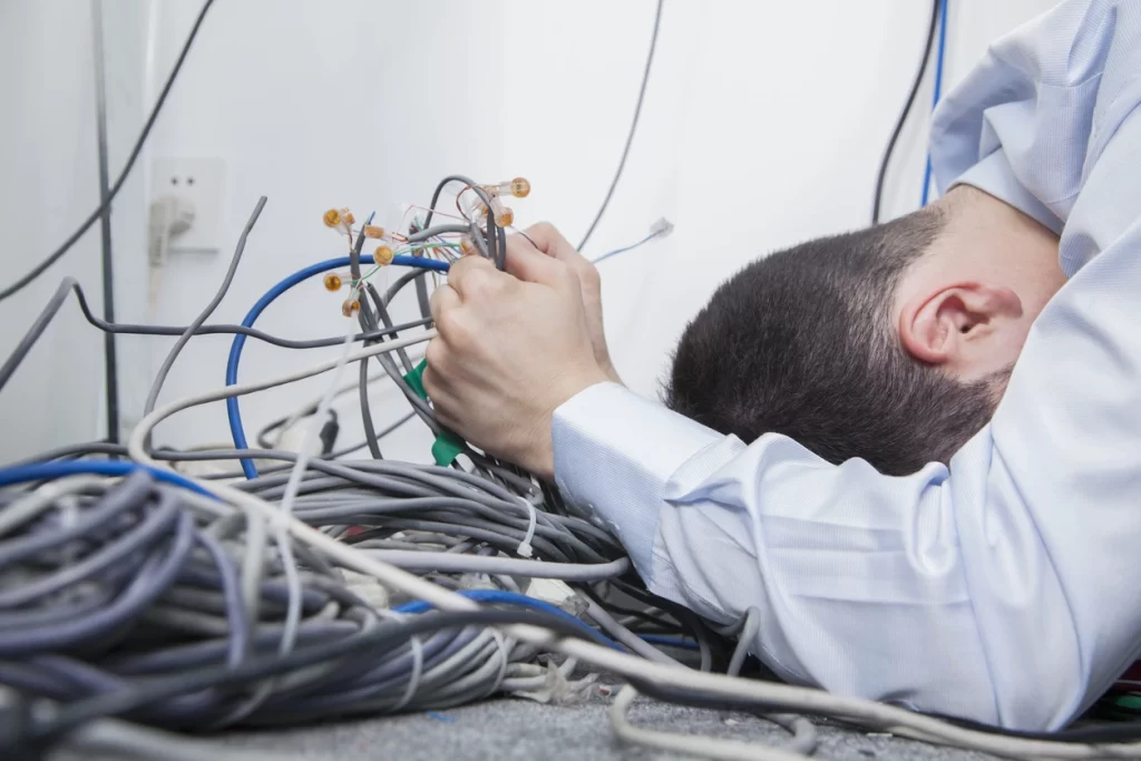 Man frustrated amongst mess of cables