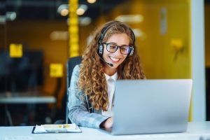Call center agent with headset working on support hotline in modern office. Video conference. Оnline training.