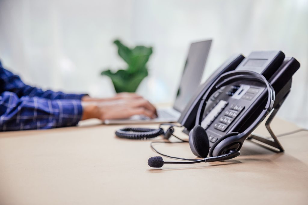 Communication support, call center and customer service help desk. telephone devices with VOIP headset in office.Customer service support (call center) concept.